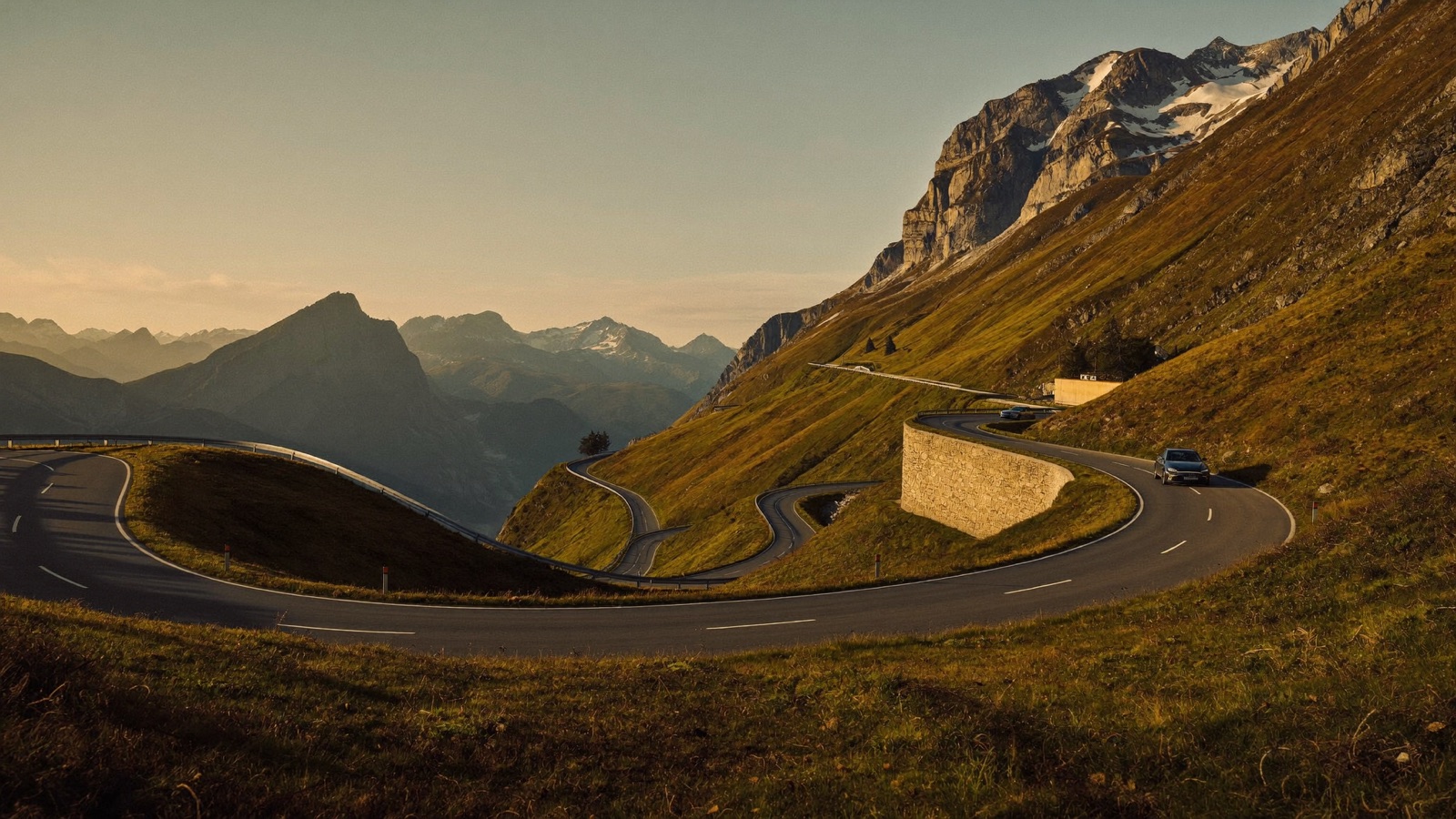 Auto auf einer Alpenpassstrasse in der Schweiz mit Blick auf Spritverbrauch und Tankkosten